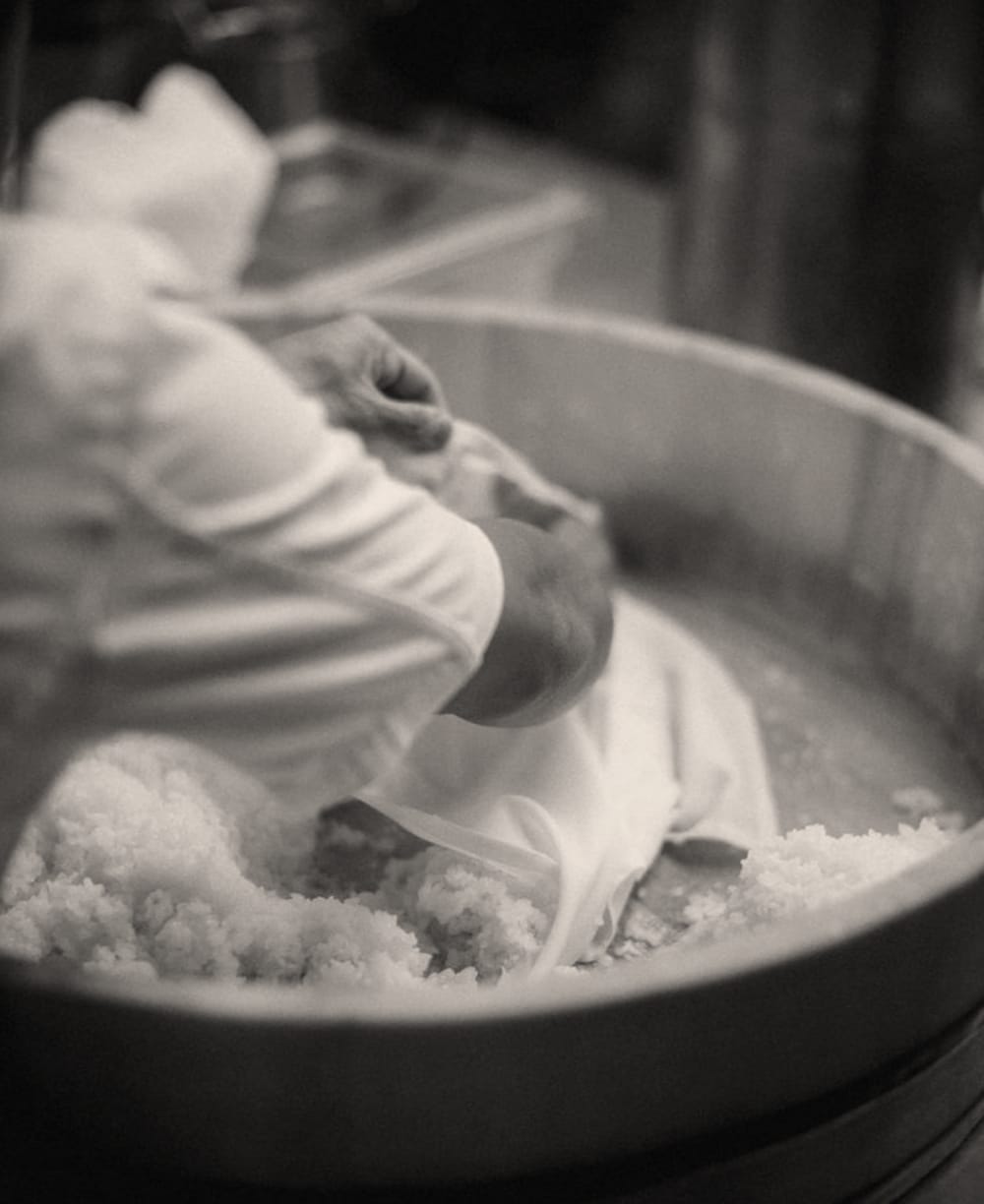 A close-up of a chef preparing rice in a large bowl.