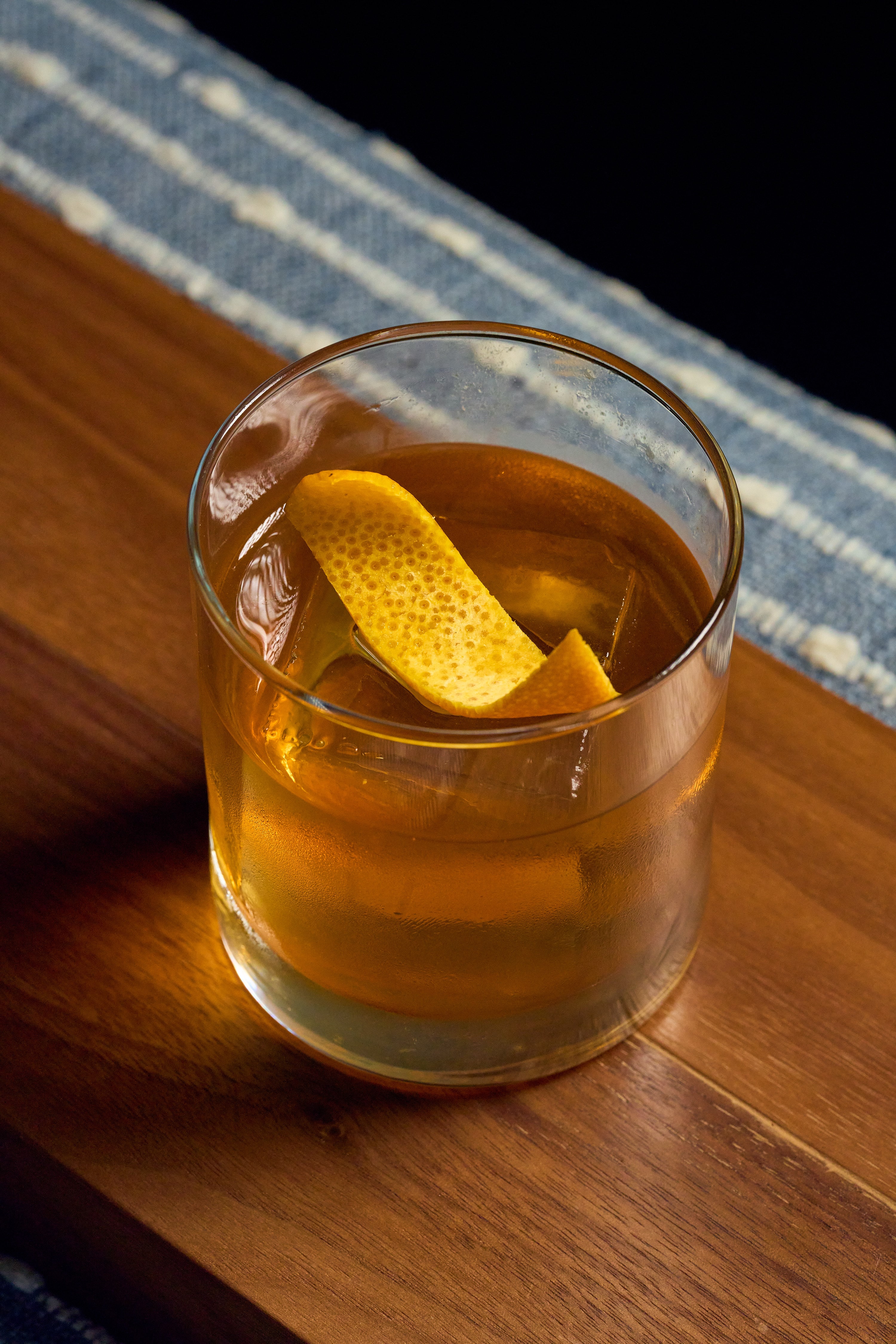 whiskey cocktail on wood board at uchiko