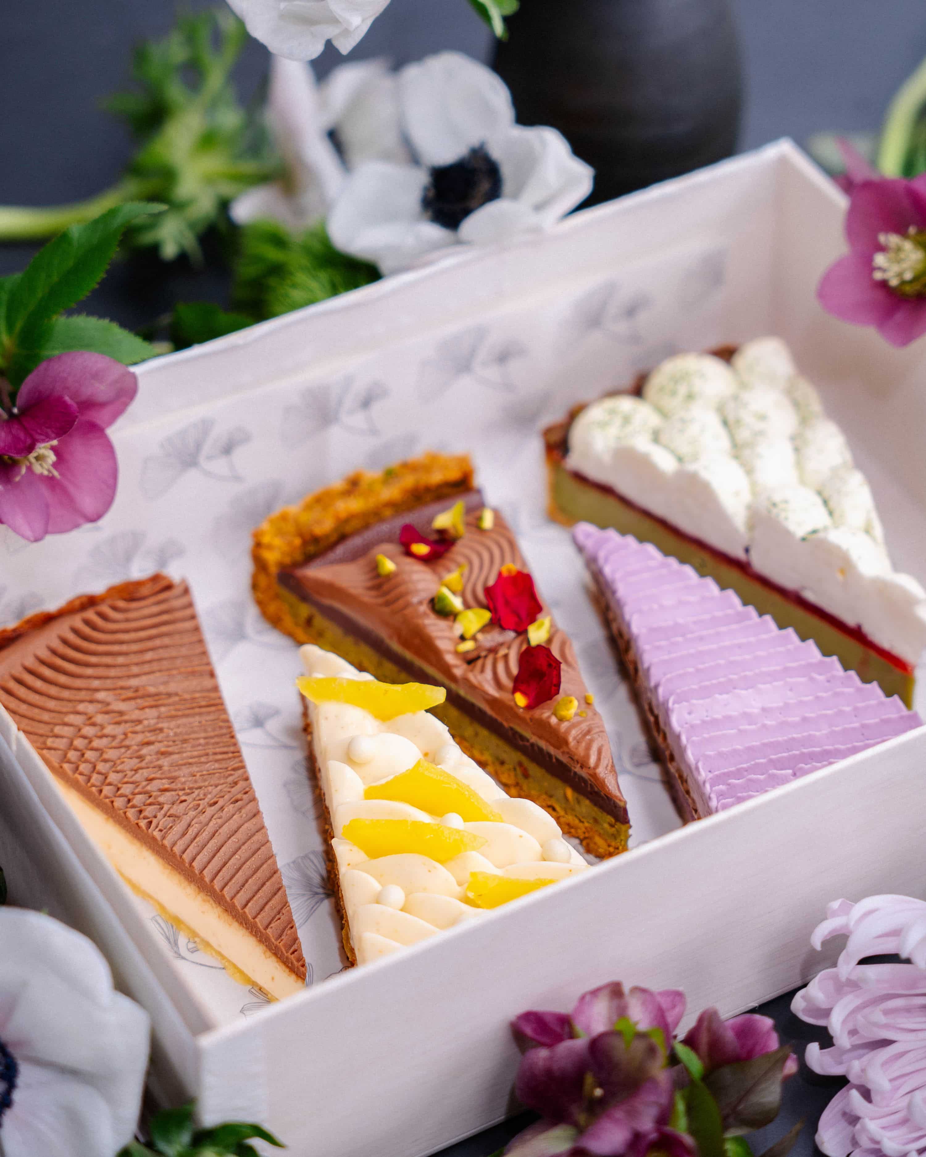 five slices of limited edition tarts in a white box with flowers